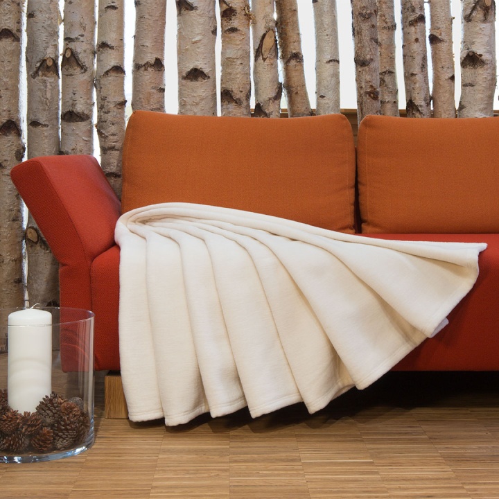 Plüschdecke in hellem Naturton ausgebreitet auf einem Sofa Plüschdecke in hellem Naturton ausgebreitet auf einem Sofa
