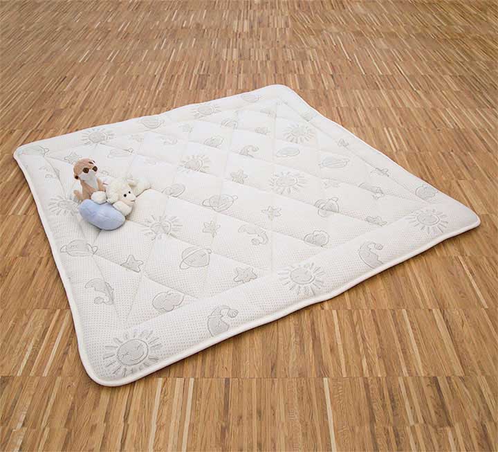 Krabbeldecke mit Sonne-Mondmuster auf dem Boden Krabbeldecke mit Sonne-Mondmuster auf dem Boden