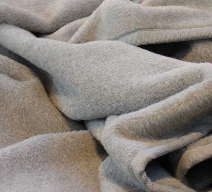 Decke in der Farbstellung silbergrau mit Strukturband-Einfassung aus Wolle Decke in der Farbstellung silbergrau mit Strukturband-Einfassung aus Wolle
